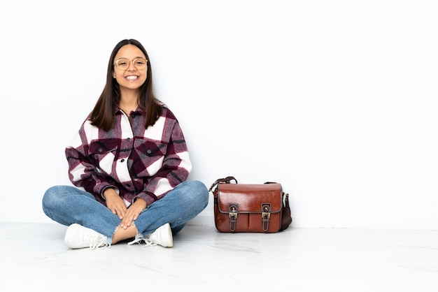 Mulher jovem estudante sentada no chão