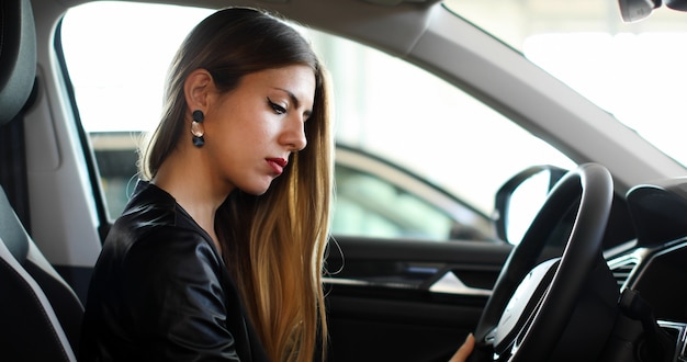 Mulher jovem, examinando, um, carro novo, em, um, showroom