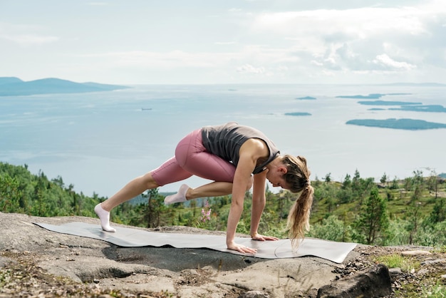 Mulher jovem exercício treino de ioga A postura de asana é harmonia com a natureza Usa meditação de tapete