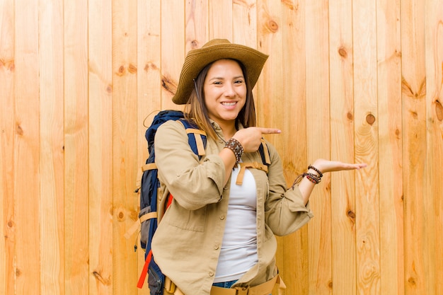 Mulher jovem explorador latina contra a parede de madeira