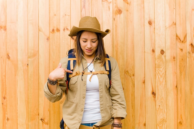 Mulher jovem explorador latino contra o fundo da parede de madeira