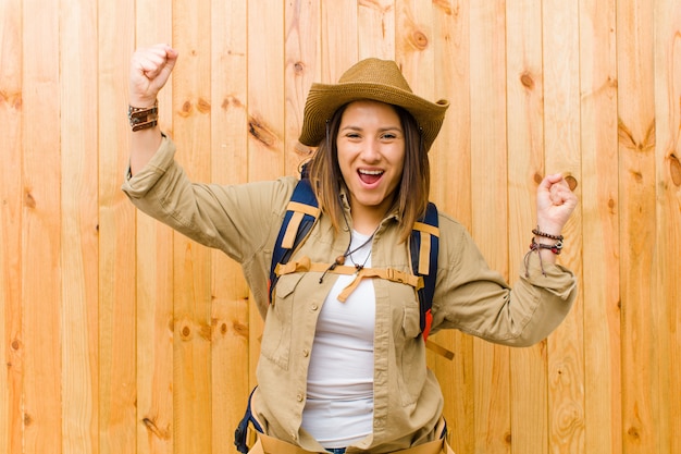 Mulher jovem explorador latino na parede de madeira