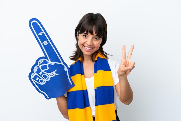 Mulher jovem fã de esportes de raça mista isolada em fundo branco sorrindo e mostrando sinal de vitória