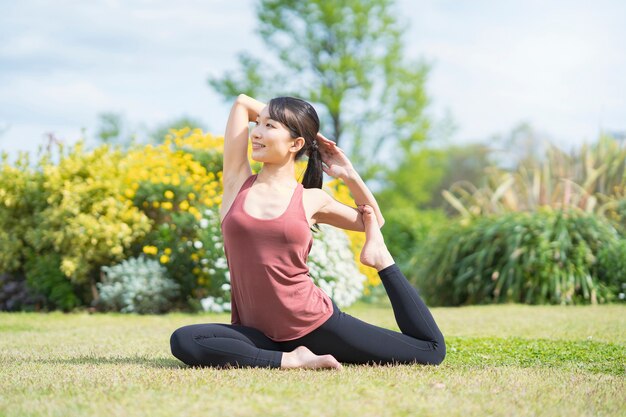 Mulher jovem fazendo ioga em um parque verde em um dia bom