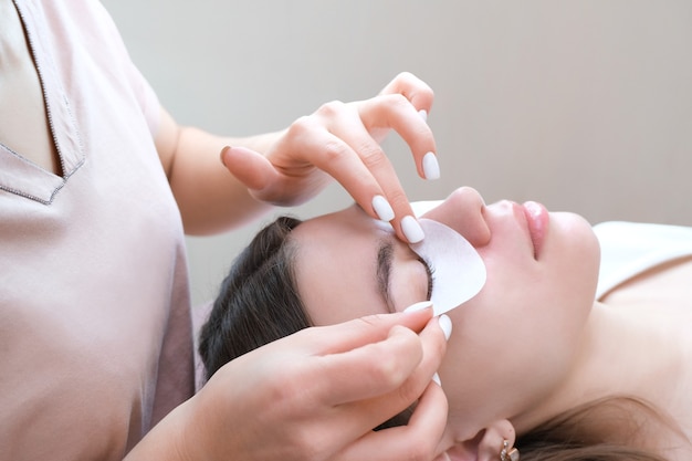 Mulher jovem fazendo procedimento de laminação dos cílios em um salão de beleza, close-up