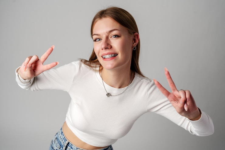 Foto mulher jovem fazendo um sinal de paz com as mãos no estúdio