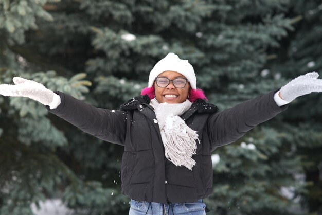 Foto mulher jovem feliz brincando com neve em um dia frio de inverno