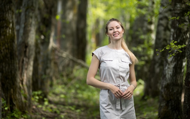 Mulher jovem feliz caminhando no parque de verão