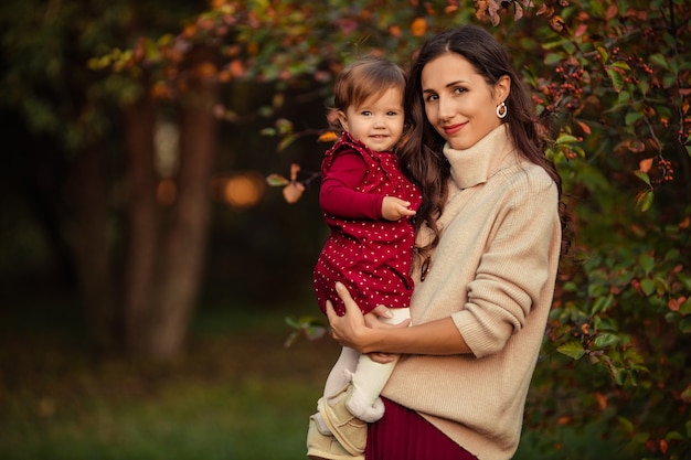 Mulher jovem feliz com a filha nos braços