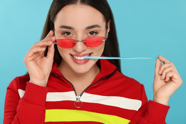 Foto mulher jovem feliz com chiclete em fundo azul claro