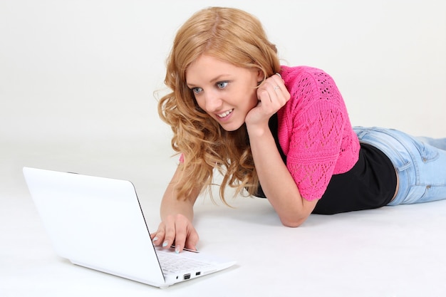 Mulher jovem feliz com laptop sobre branco