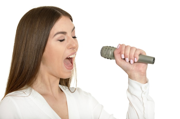 Foto mulher jovem feliz com microfone no fundo branco