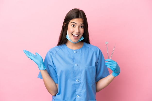 Mulher jovem feliz com uma tigela de cereais sobre uma parede azul isolada