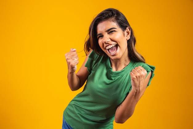 Mulher jovem feliz comemorando com o conceito de realização. sim