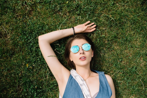 Mulher jovem feliz deitada na grama verde rindo de emoção. copie o espaço, vista de cima, copie o espaço