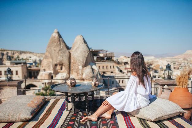 Mulher jovem feliz durante o nascer do sol assistindo balões de ar quente na capadócia turquia