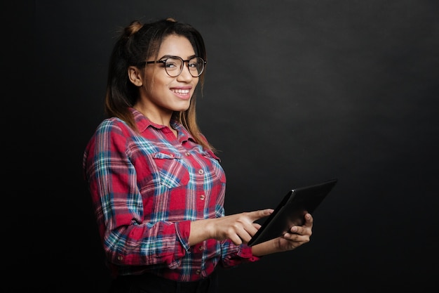 Foto mulher jovem feliz e positiva expressando alegria e usando a mesa enquanto está dentro de casa