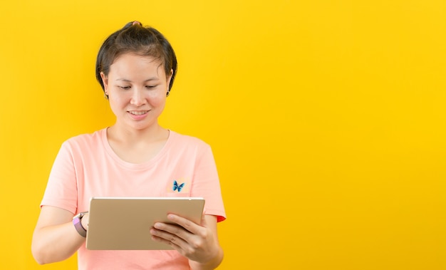 Mulher jovem feliz em fazer compras online em casa contra um fundo amarelo