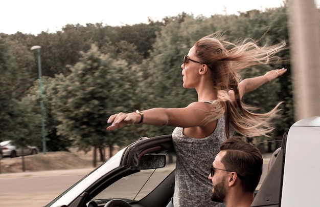 Foto mulher jovem feliz em pé no carro conversível