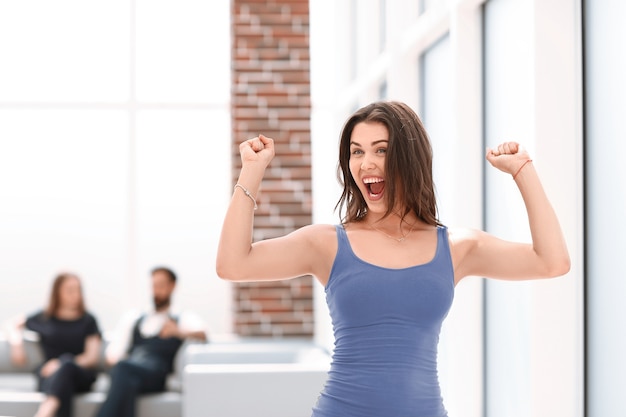 Mulher jovem feliz em pé no escritório do banco. Foto com espaço de cópia