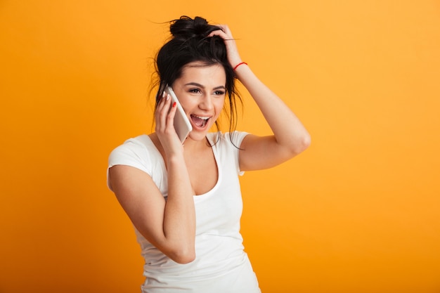 Mulher jovem feliz falando pelo telefone móvel.