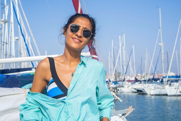 Foto mulher jovem feliz num barco e na praia.