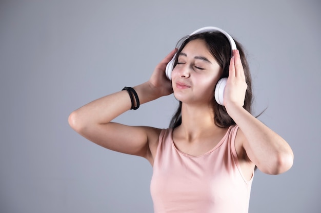 Mulher jovem feliz ouvindo com fones de ouvido