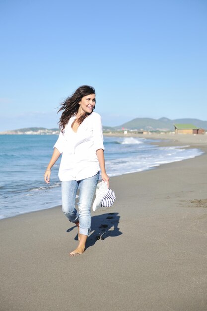 Mulher jovem feliz relaxa na bela praia de manhã