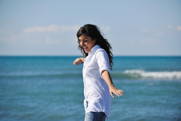 Mulher jovem feliz relaxa na bela praia de manhã