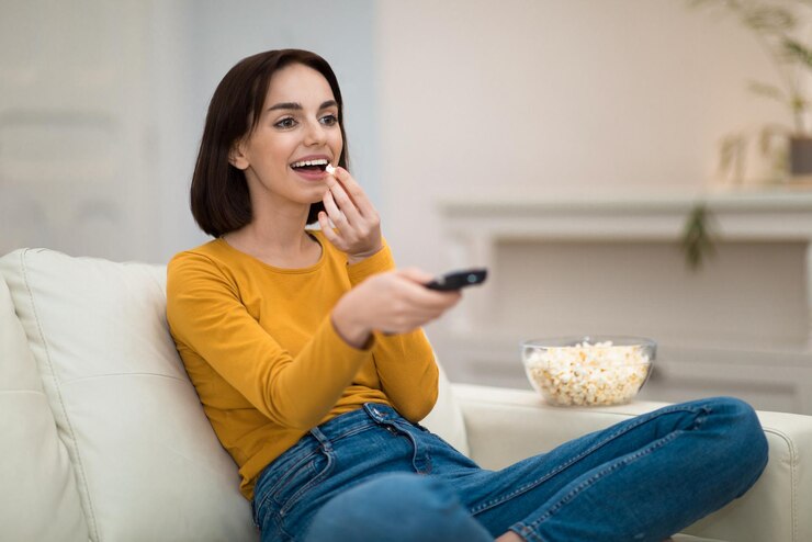 Foto mulher jovem feliz relaxando em casa assistindo tv