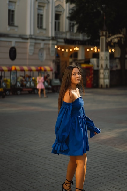 Mulher jovem feliz retrato com vestido azul, rindo, olhando para a câmera em pé na rua urbana ba.