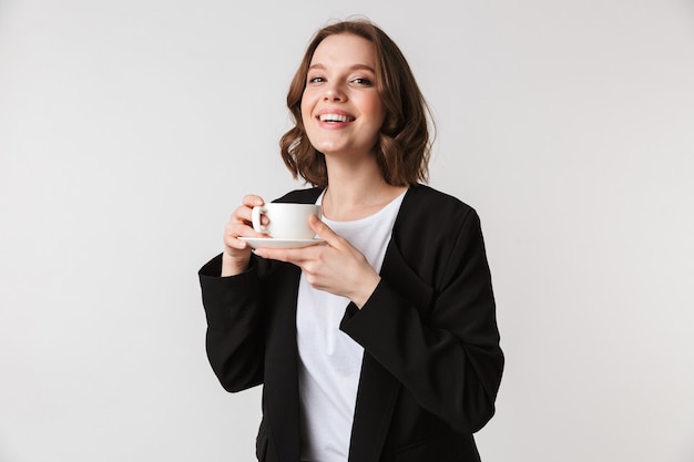 Mulher jovem feliz segurando a xícara de café.