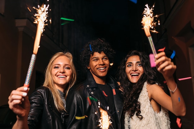 Mulher jovem feliz segurando brilhante à noite