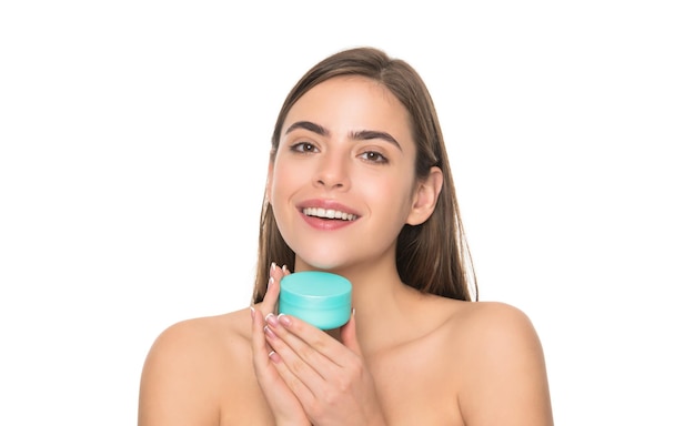 Mulher jovem feliz segurar o frasco de creme para pele do rosto isolada no fundo branco, tratamento facial.