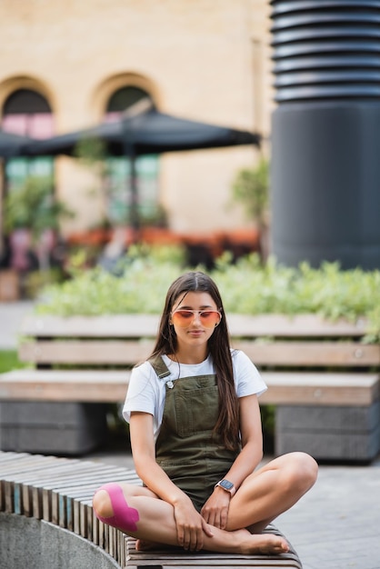 Mulher jovem feliz sentada ao ar livre em posição de ioga