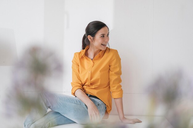 Mulher jovem feliz sentada em uma mesa