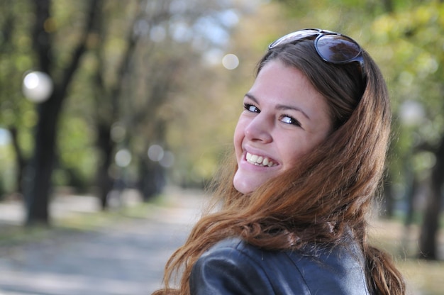 Mulher jovem feliz sorrindo ao ar livre no parque