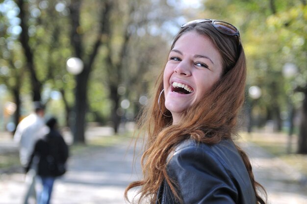 Mulher jovem feliz sorrindo ao ar livre no parque