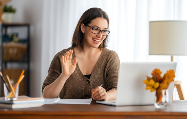 Mulher jovem feliz trabalhando on-line, assistindo ao podcast do webinar no laptop