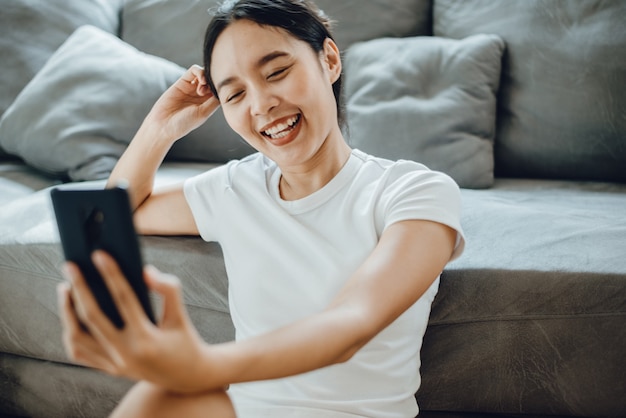 Mulher jovem fica em casa e faz videochamadas on-line no ciberespaço com computador laptop ou smartphone, tecnologia de comunicação empresarial para falar de trabalho, estilo de vida feminino para conferência remota