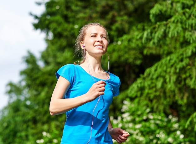 Mulher jovem fitness correndo na trilha da floresta.