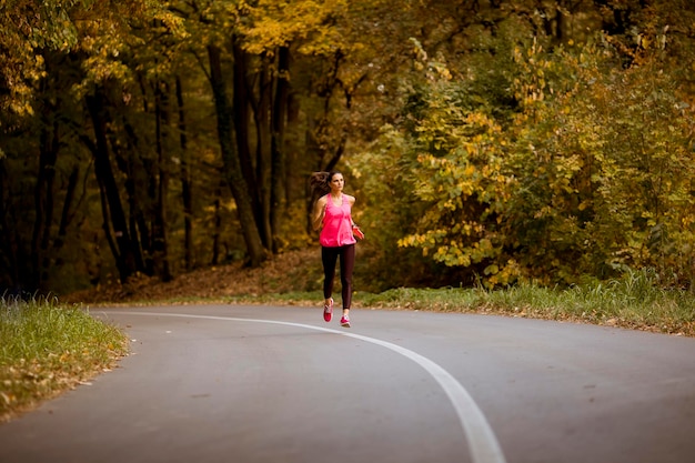 Mulher jovem fitness correndo na trilha da floresta