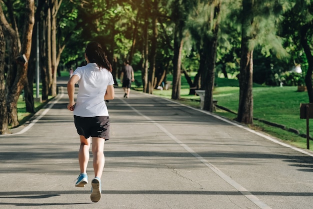 Mulher jovem fitness correndo no parque ao ar livre