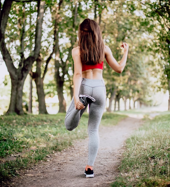 Mulher jovem fitness exercitando no parque