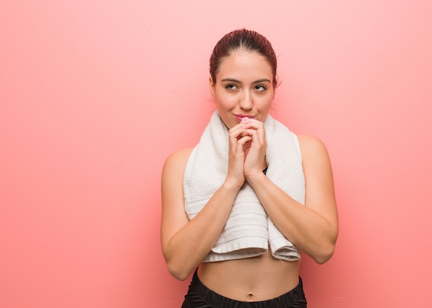 Mulher jovem fitness rezando muito feliz e confiante