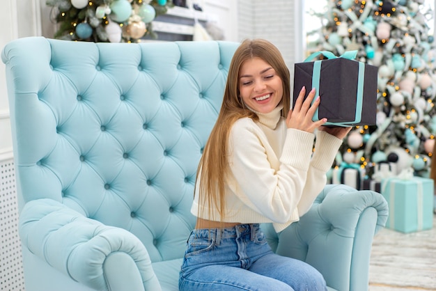 mulher jovem fofa feliz comemorando o natal em casa com presentes feche o retrato