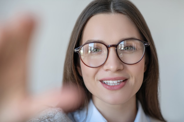 Foto mulher jovem. foto na cabeça de uma mulher de cabelo comprido usando óculos, parecendo positiva