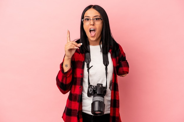 Mulher jovem fotografia caucasiana com um braço isolado no fundo rosa, tendo uma ideia, o conceito de inspiração.