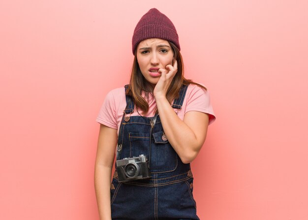 Mulher jovem fotógrafo bonito roer unhas, nervoso e muito ansioso