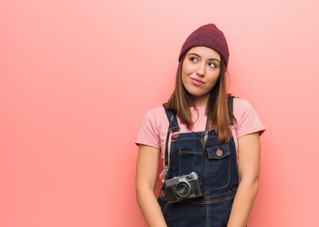 Mulher jovem fotógrafo bonito sonhando em alcançar objetivos e finalidades